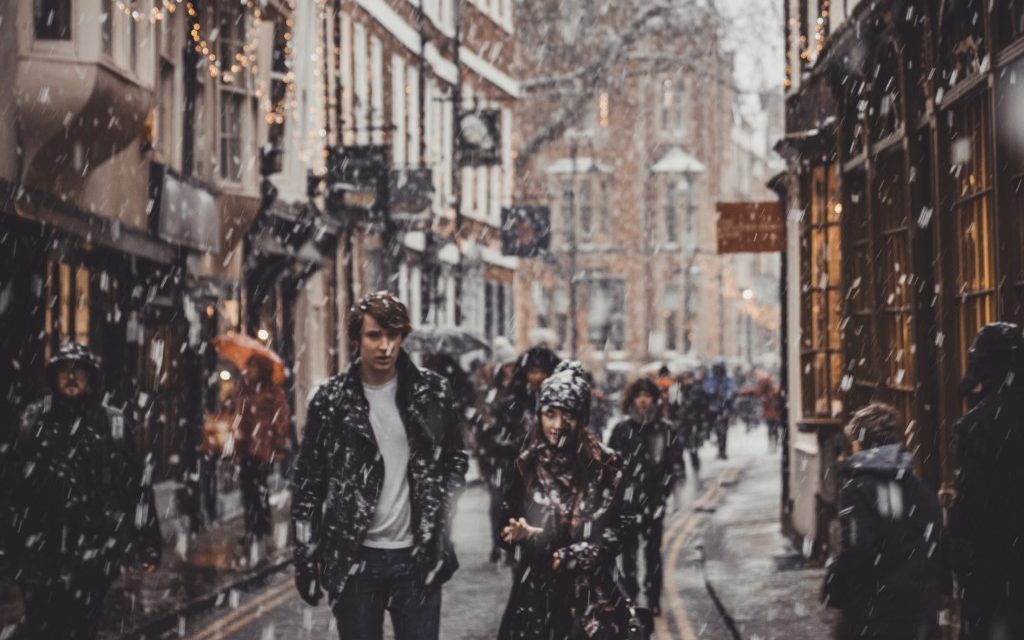 A young couple walks through the snow on the Shambles in York.